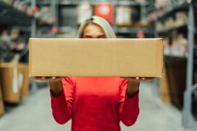 Woman in logistics warehouse with package