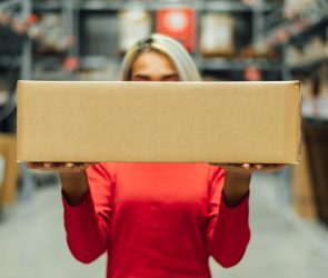 Woman in logistics warehouse with package